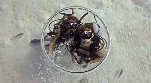 Two Advanced open water divers looking to the surface through a bubble ring