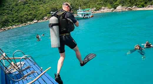 Discover scuba diving jump from the back of the dive boat