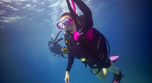 PADI Nitrox Specialty Diver Kurs Taucher in pinker Ausrüstung steigen ab