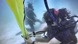 PADI Search and Recovery Specialty course diver using lift bag underwater