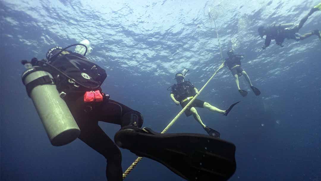 PADI Discover Scuba Diving students descend with instructor